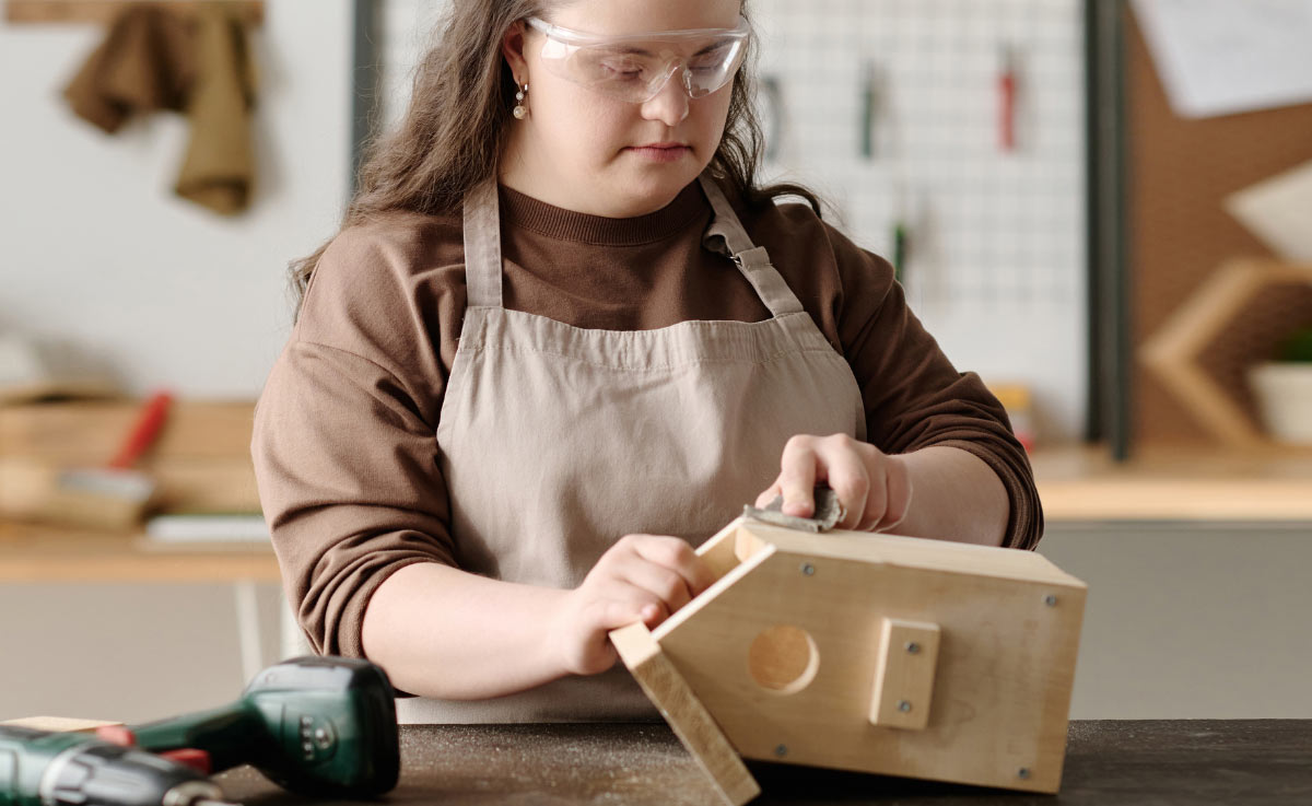 Image of a girl with developmental disability working in wood shop